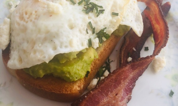 Egg and avocado toast with slice of bacon