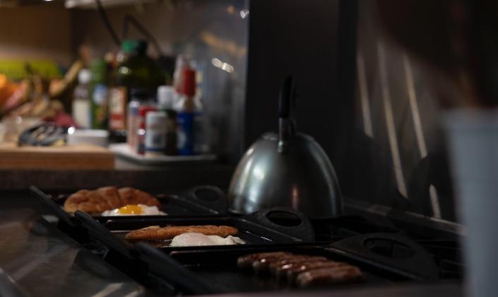 Eggs and sausages cooking on stove