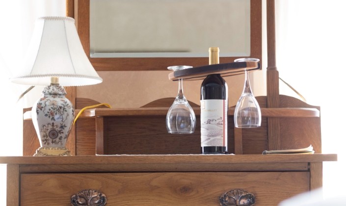 Dresser with bottle of wine and glasses