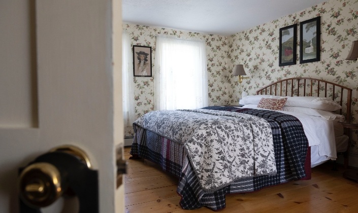 Large bed with dark blue quilt